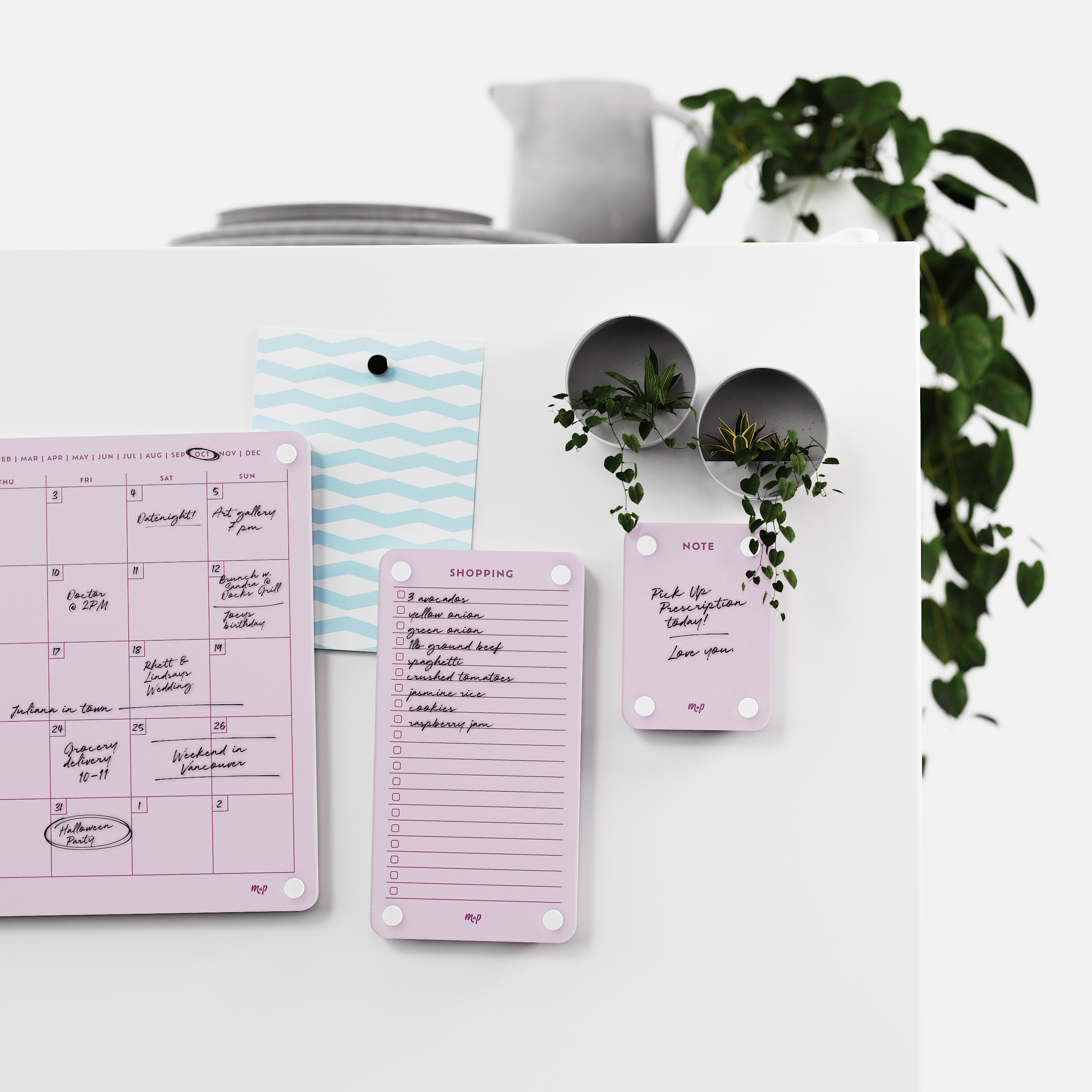 Ballet pink monthly calendar, shopping list and note board on a white kitchen wall with magnetic planters
